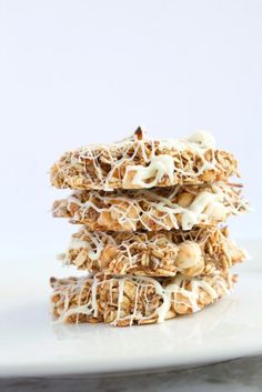 three cookies stacked on top of each other with white frosting and nuts in the middle