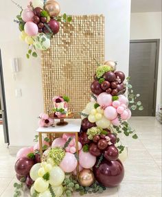 a table topped with lots of balloons and greenery