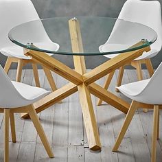 a glass table with four white chairs around it