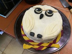 a cake with white frosting and black eyes sitting on top of a metal plate