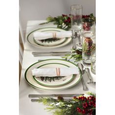 the table is set with place settings for christmas dinner