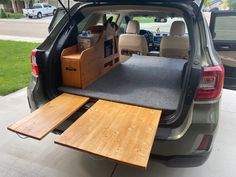 the back end of a car with an open hatchback door and wooden flooring