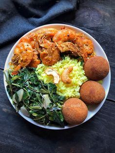 a white plate topped with shrimp, rice and spinach next to other food items