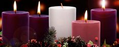 five candles with christmas decorations and pine cones