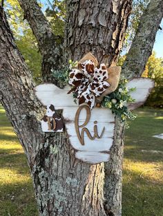 a wooden sign hanging on the side of a tree