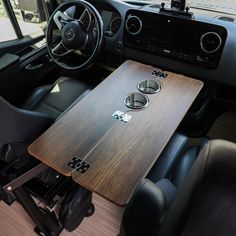 the interior of a vehicle with a wooden table and steering wheel