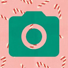 the camera is surrounded by candy canes on a pink background with green and red colors