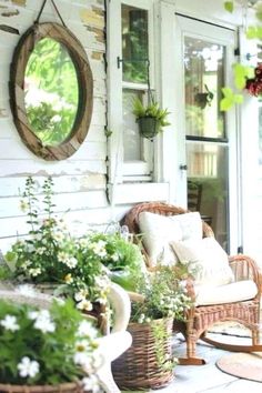 the porch is decorated with wicker furniture and potted plants