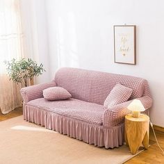 a living room with a couch, lamp and rug on the floor in front of a window