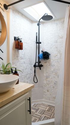 a bathroom with a shower, sink and mirror