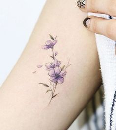 a woman's arm with purple flowers on it