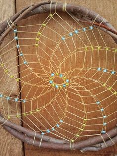 a close up of a piece of string art on a wooden surface with wood planks