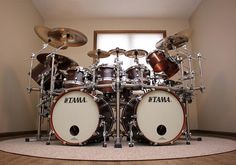 a set of drums sitting on top of a floor next to a window in a room