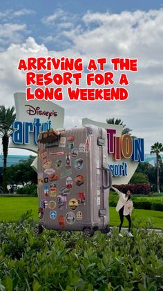 a woman standing in front of a suitcase with stickers on it and the words arriving at the resort for a long weekend