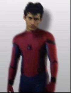 a blurry image of a man in a red and blue suit with his hands on his hips