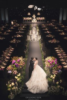 a bride and groom standing in front of a chandelier at their wedding reception