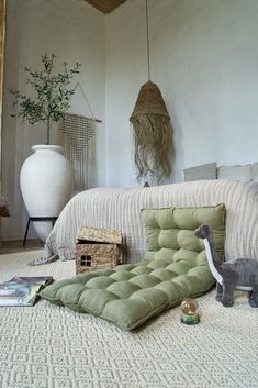 a room with a bed, pillows and stuffed animals on the floor next to it