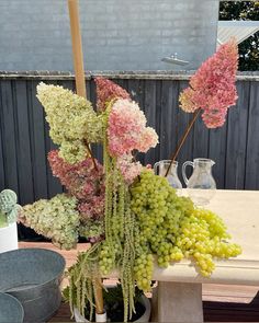 a bunch of flowers that are sitting on top of a table with an umbrella in the background