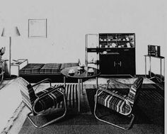 a black and white photo of a living room with two chairs, a coffee table and a couch