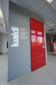 the entrance to an office building with red doors and grey walls, in front of a large sign that reads japan