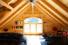 a loft with wooden walls and vaulted ceiling, leather couches in the foreground