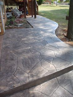 an outdoor patio with concrete steps and trees