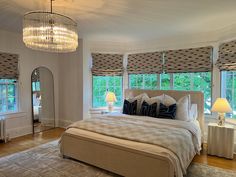 a large bed sitting in a bedroom next to two windows