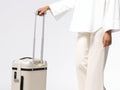 a woman standing next to a white suitcase