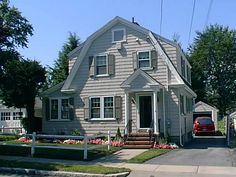 a house with a car parked in front of it on the side of the road