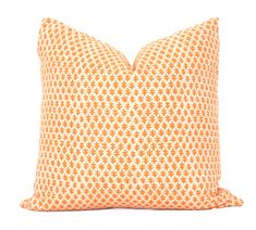 an orange and white pillow on a white background