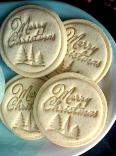 some cookies are on a plate with merry christmas written on the top and bottom one