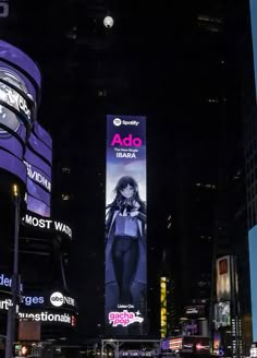 a city street filled with lots of traffic and tall buildings covered in advertisements at night