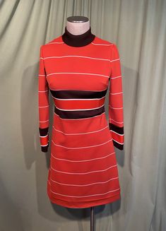 "This is a cute vintage dress from the 70s. Label reads, Verona Knits. No size tags. The bust measures 32\", waist 30\", see measurements below. Made of a rust orange, brown & white horizontal stripe polyester knit. It has long sleeves & a mock turtle neck. The rust orange stripes inside the dark brown stripes at the waist on the sleeves & a slightly thicker knit. The dress is skims the body & it is not lined. The sleeves are wrist length. The neckline is fold over mock turtleneck. Zips in the b Retro A-line Vintage Dress For Fall, Retro Fitted Mini Dress For Fall, Retro Striped Knee-length Dress, Fitted Retro Mini Dress For Fall, Vintage Fitted Long Sleeve Mini Dress, Retro Fitted A-line Vintage Dress, Fitted Retro A-line Vintage Dress, Fitted A-line Retro Vintage Dress, Retro Striped Lined Dress