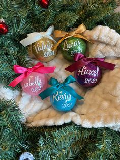 christmas ornaments with names on them sitting in a tree