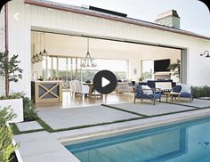 an outdoor living area with pool and dining room in the back ground, surrounded by greenery