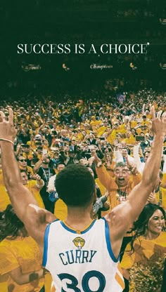 a man with his arms up in the air surrounded by fans at a basketball game