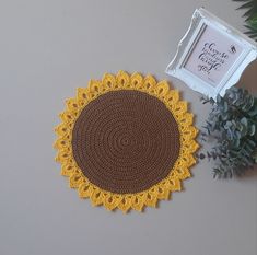 a crocheted doily sits next to a plant