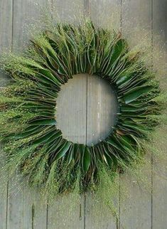 a wreath made out of grass on top of a wooden fence