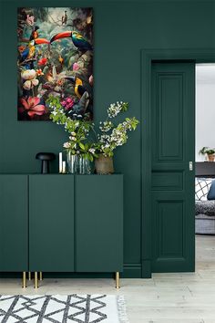 a living room with dark green walls and white rugs on the hardwood flooring