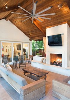 a living room filled with furniture and a flat screen tv mounted on the wall above a fire place