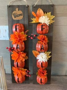 two pumpkins decorated with flowers and letters