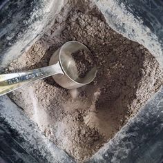 a scoop of dirt sitting on top of a pile of dirt next to a measuring cup