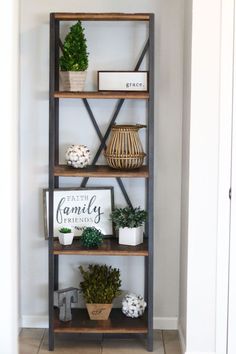 a book shelf with plants and pictures on it