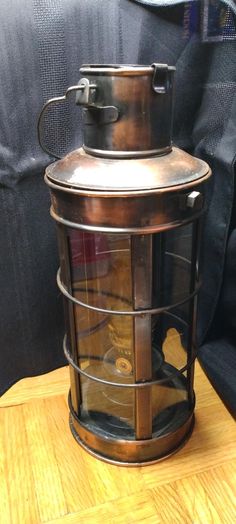 a metal lantern sitting on top of a wooden table