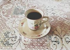 a cup of coffee sitting on top of a saucer next to a doily