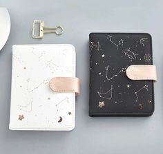 two notebooks with gold stars on them next to a white cup and saucer