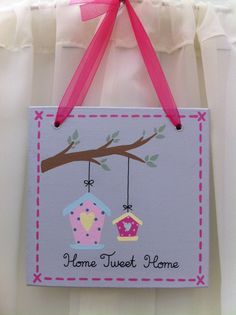 a sign hanging from the side of a door with a pink ribbon on it that says home sweet home