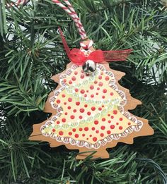 a christmas tree ornament hanging from a pine tree with candy canes on it