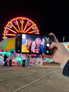 a person taking a photo with their cell phone at an amusement park