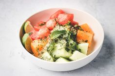 a white bowl filled with fruit and vegetables